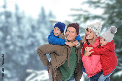 Happy family spending time together near winter forest