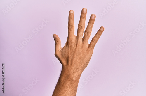 Arm and hand of caucasian young man over pink isolated background counting number 5 showing five fingers