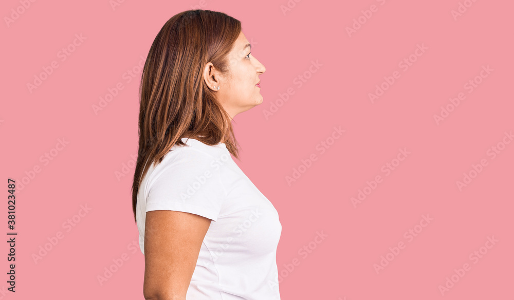 Middle age latin woman wearing casual white tshirt looking to side, relax profile pose with natural face and confident smile. Middle age latin woman wearing casual white tshirt looking to side, relax profile pose with natural face and confident smile.