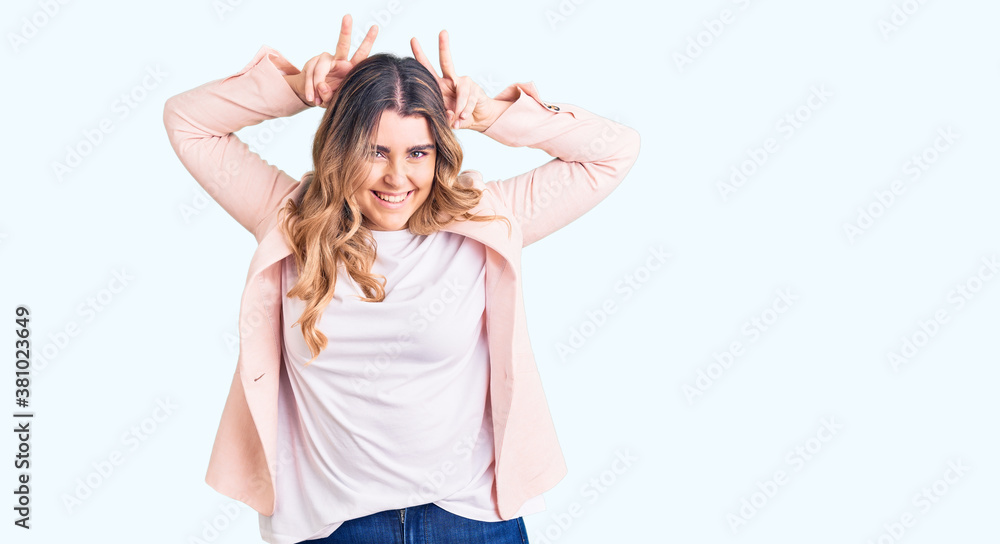 Young caucasian woman wearing business clothes posing funny and crazy with fingers on head as bunny ears, smiling cheerful