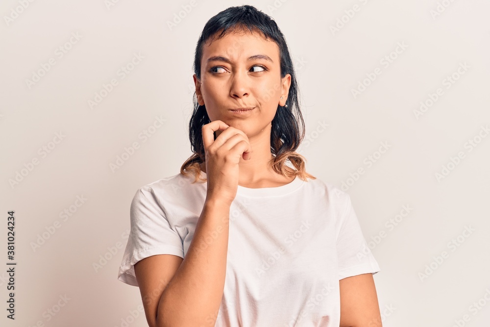 Young woman wearing casual clothes thinking concentrated about doubt with finger on chin and looking up wondering Young woman wearing casual clothes thinking concentrated about doubt with finger on chin and looking up wondering