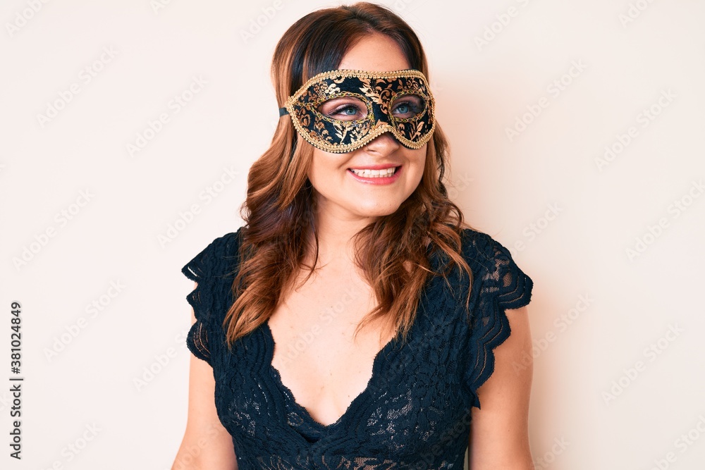 Young beautiful caucasian woman wearing venetian carnival mask looking to side, relax profile pose with natural face and confident smile. Young beautiful caucasian woman wearing venetian carnival mask looking to side, relax profile pose with natural face and confident smile.