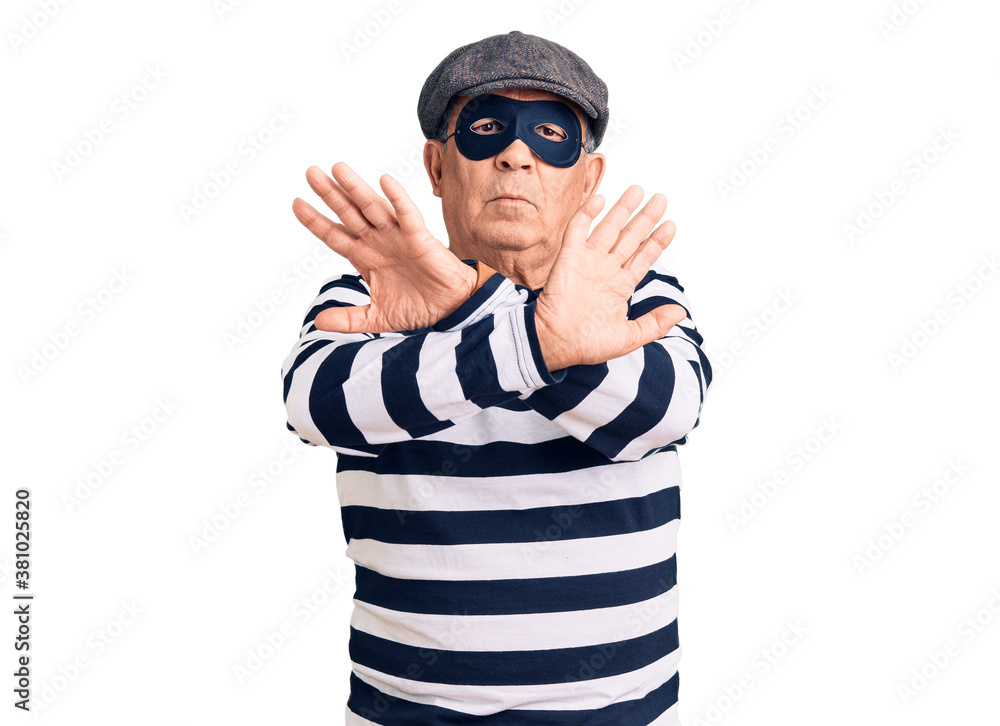 Fototapeta premium Senior handsome man wearing burglar mask and t-shirt rejection expression crossing arms doing negative sign, angry face