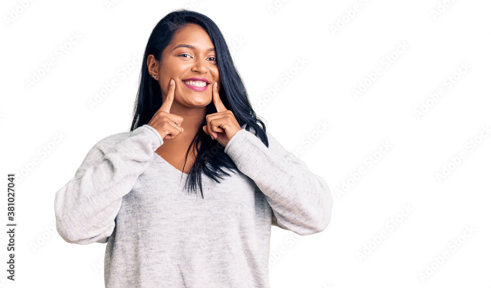 Hispanic woman with long hair wearing casual clothes smiling with open mouth, fingers pointing and forcing cheerful smile Hispanic woman with long hair wearing casual clothes smiling with open mouth, fingers pointing and forcing cheerful smile