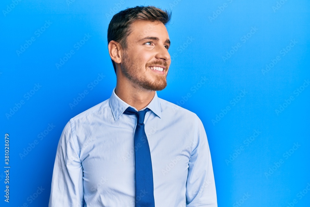Handsome caucasian man wearing business shirt and tie looking away to side with smile on face, natural expression. laughing confident. Handsome caucasian man wearing business shirt and tie looking away to side with smile on face, natural expression. laughing confident.
