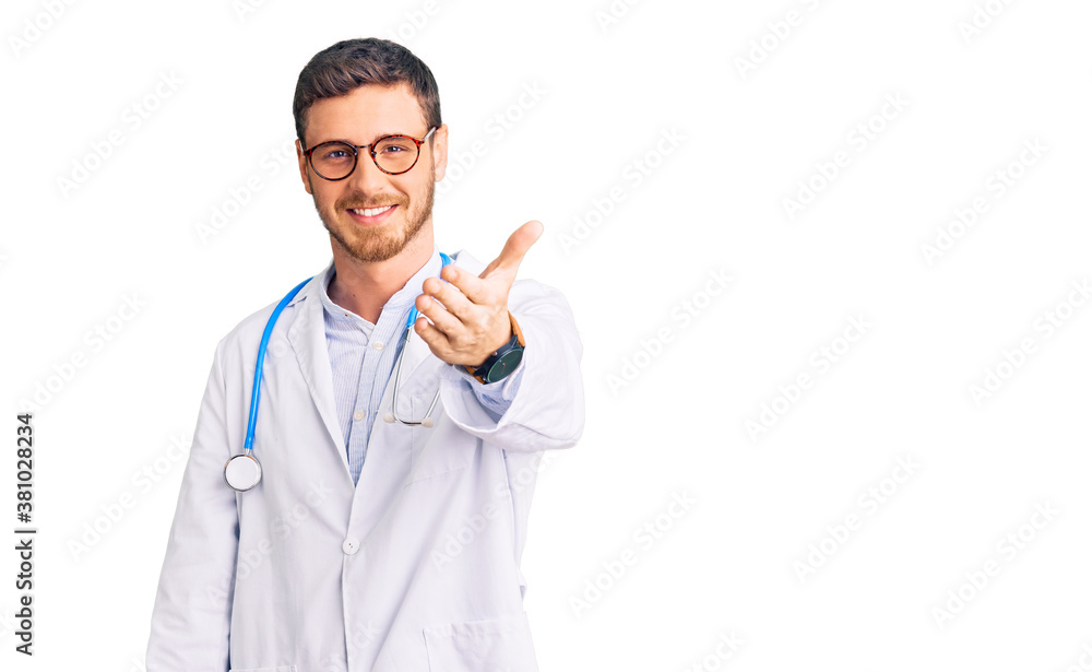 Handsome young man with bear wearing doctor uniform smiling friendly offering handshake as greeting and welcoming. successful business. Handsome young man with bear wearing doctor uniform smiling friendly offering handshake as greeting and welcoming. successful business.