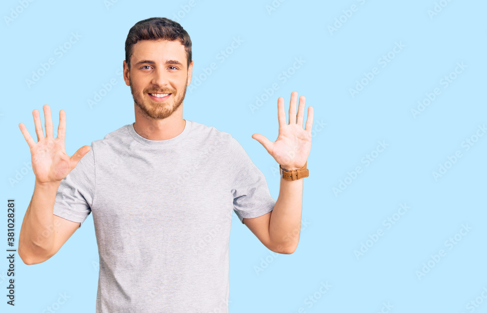 Naklejka premium Handsome young man with bear wearing casual tshirt showing and pointing up with fingers number ten while smiling confident and happy.