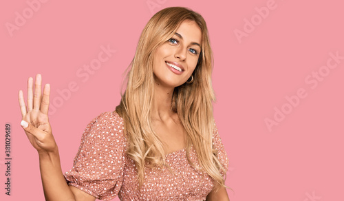Beautiful blonde young woman wearing summer top showing and pointing up with fingers number four while smiling confident and happy.