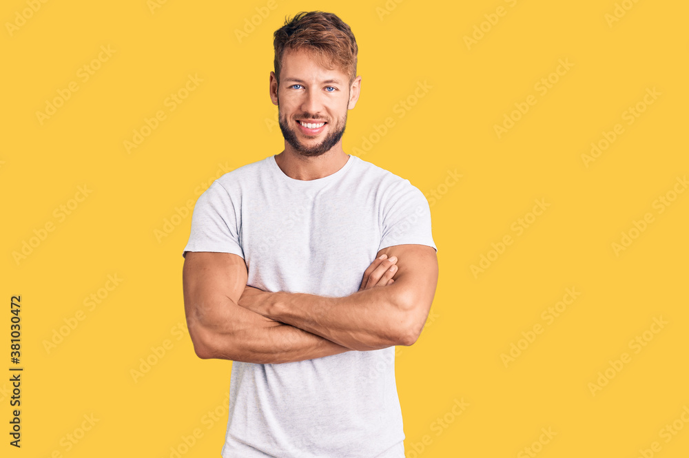 Young caucasian man wearing casual white tshirt happy face smiling with crossed arms looking at the camera. positive person. Young caucasian man wearing casual white tshirt happy face smiling with crossed arms looking at the camera. positive person.