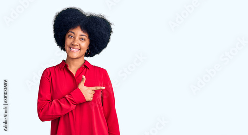 Young african american girl wearing casual clothes cheerful with a smile on face pointing with hand and finger up to the side with happy and natural expression