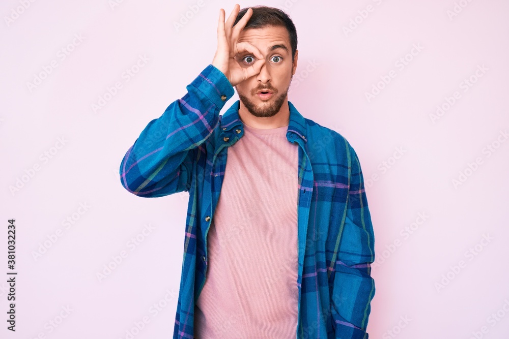 Young handsome man wearing casual clothes doing ok gesture shocked with surprised face, eye looking through fingers. unbelieving expression. Young handsome man wearing casual clothes doing ok gesture shocked with surprised face, eye looking through fingers. unbelieving expression.