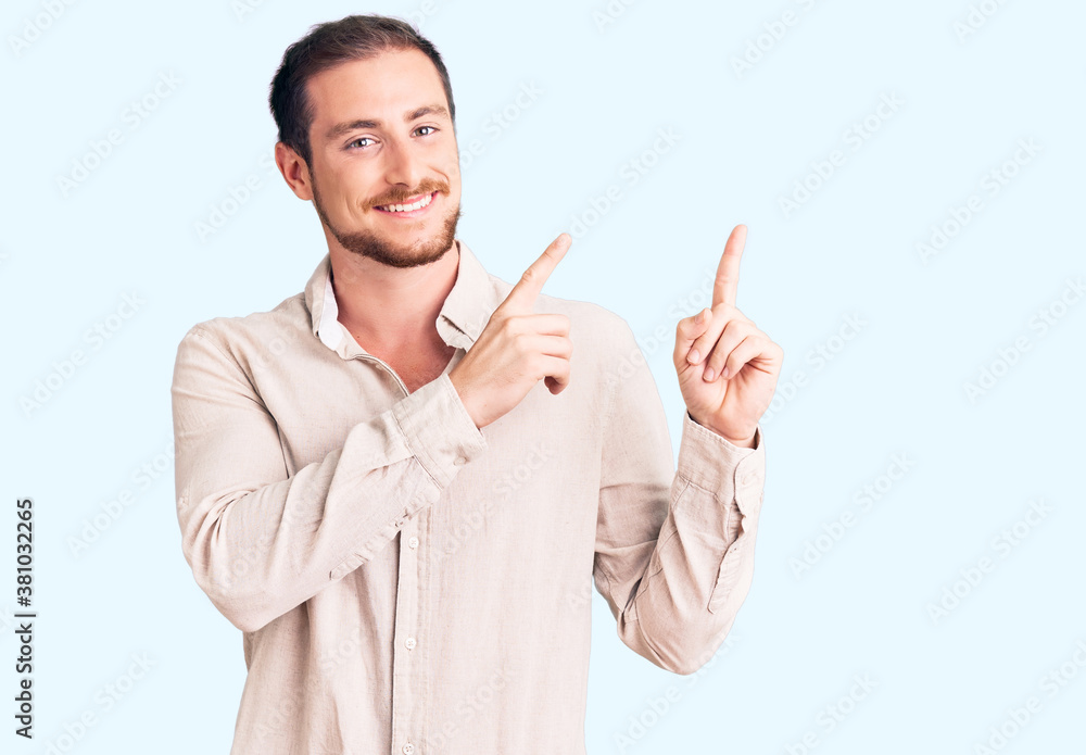 Young handsome caucasian man wearing casual clothes smiling and looking at the camera pointing with two hands and fingers to the side. Young handsome caucasian man wearing casual clothes smiling and looking at the camera pointing with two hands and fingers to the side.