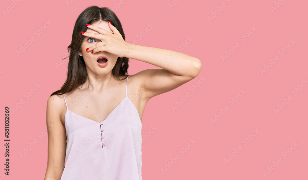 Young beautiful caucasian girl wearing casual clothes peeking in shock covering face and eyes with hand, looking through fingers with embarrassed expression. Young beautiful caucasian girl wearing casual clothes peeking in shock covering face and eyes with hand, looking through fingers with embarrassed expression.