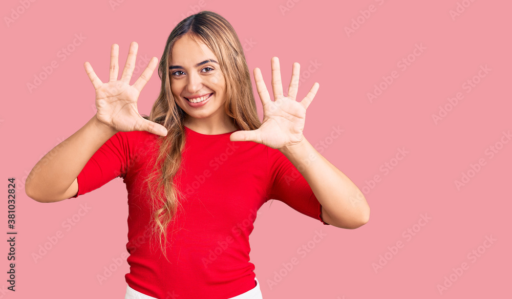 Young beautiful blonde woman wearing casual clothes showing and pointing up with fingers number ten while smiling confident and happy. Young beautiful blonde woman wearing casual clothes showing and pointing up with fingers number ten while smiling confident and happy.