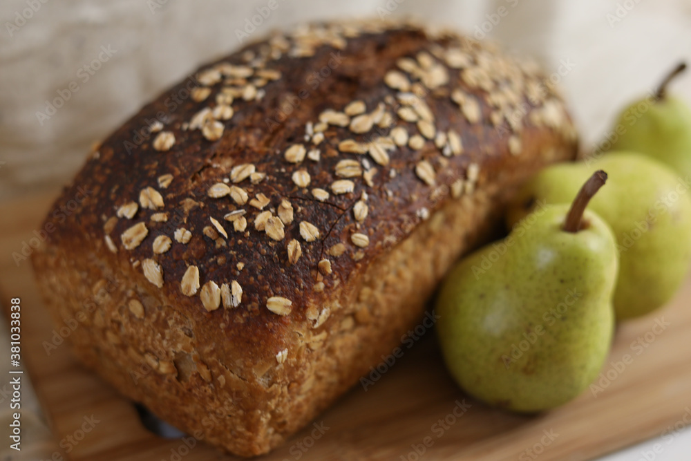 Rustic oat bread loaf with green pears