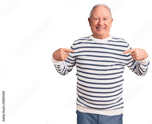 Senior handsome grey-haired man wearing casual striped sweater looking confident with smile on face, pointing oneself with fingers proud and happy.