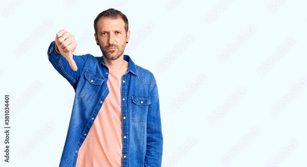 Young handsome man wearing casual clothes looking unhappy and angry showing rejection and negative with thumbs down gesture. bad expression. Young handsome man wearing casual clothes looking unhappy and angry showing rejection and negative with thumbs down gesture. bad expression.