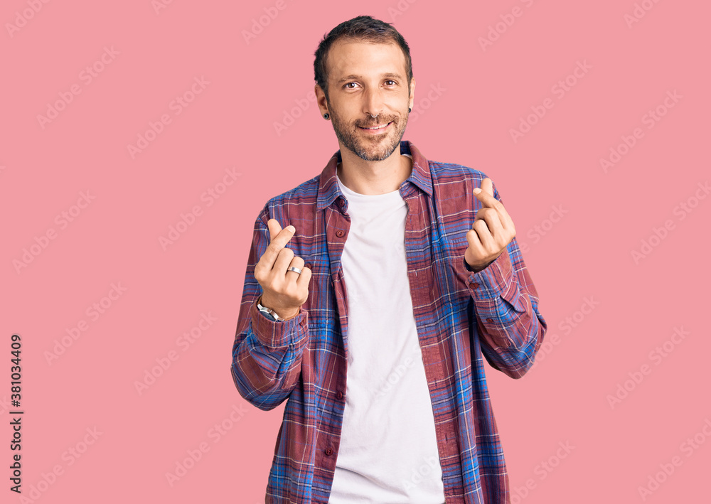 Young handsome man wearing casual clothes doing money gesture with hands, asking for salary payment, millionaire business Young handsome man wearing casual clothes doing money gesture with hands, asking for salary payment, millionaire business