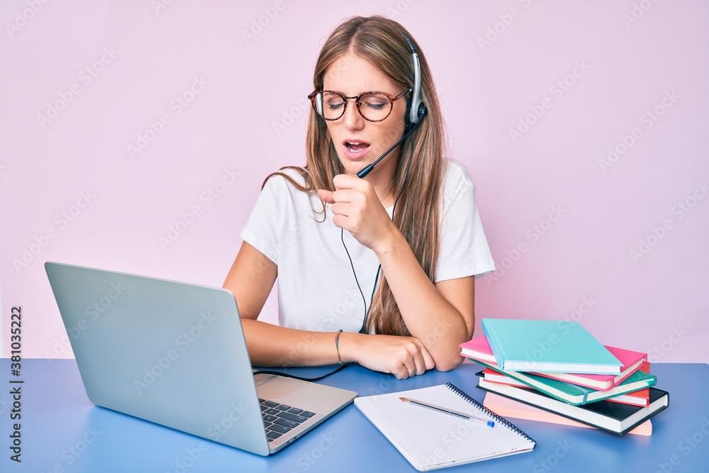 Young blonde girl wearing operator headset at the call center office feeling unwell and coughing as symptom for cold or bronchitis. health care concept. - obrazy, fototapety, plakaty 