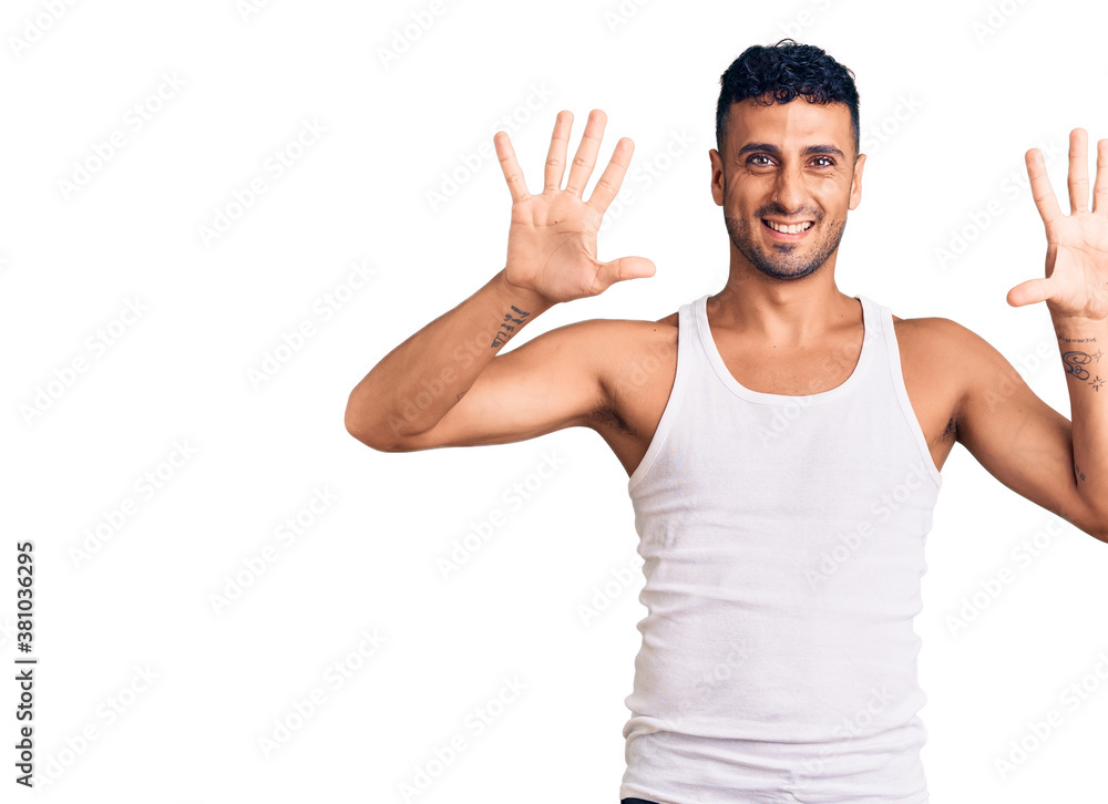 Fototapeta premium Young hispanic man wearing casual clothes showing and pointing up with fingers number ten while smiling confident and happy.