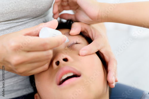 Mom hand apply a medicine to child eye