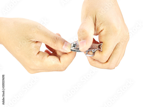 Woman cutting nails using nail clipper on white background