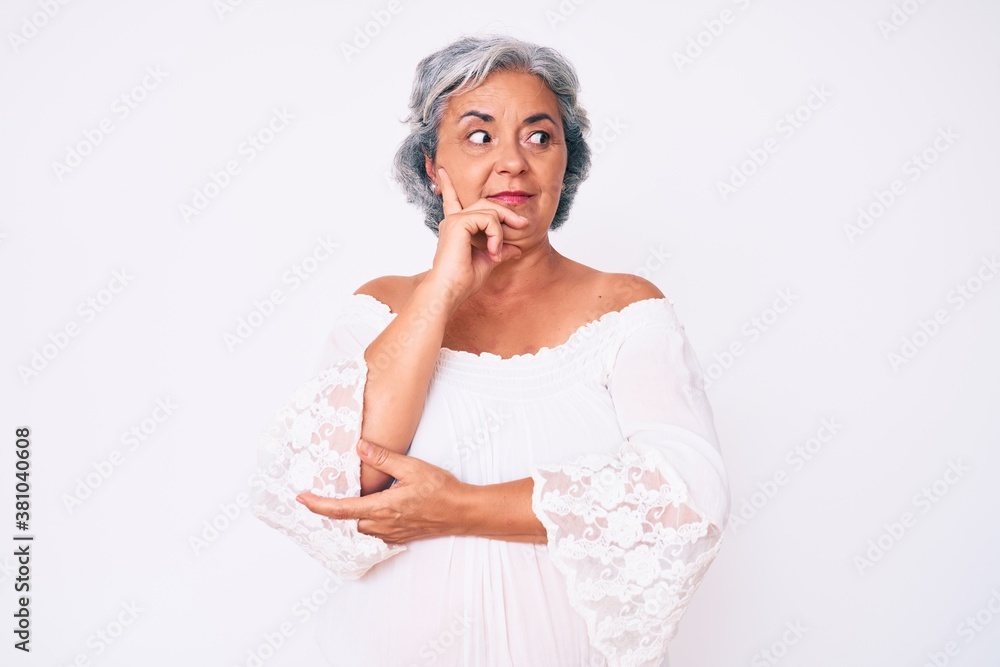 Senior hispanic grey- haired woman wearing casual clothes with hand on chin thinking about question, pensive expression. smiling with thoughtful face. doubt concept. Senior hispanic grey- haired woman wearing casual clothes with hand on chin thinking about question, pensive expression. smiling with thoughtful face. doubt concept.