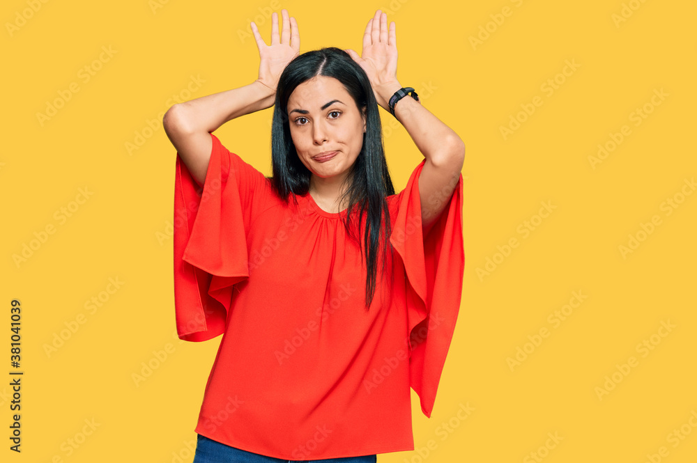 Beautiful young woman wearing casual clothes doing bunny ears gesture with hands palms looking cynical and skeptical. easter rabbit concept. Beautiful young woman wearing casual clothes doing bunny ears gesture with hands palms looking cynical and skeptical. easter rabbit concept.