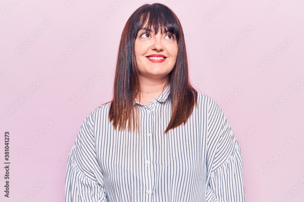 Young plus size woman wearing casual clothes looking away to side with smile on face, natural expression. laughing confident. Young plus size woman wearing casual clothes looking away to side with smile on face, natural expression. laughing confident.