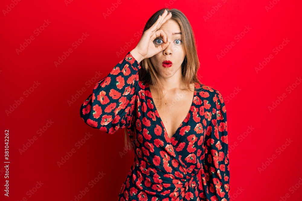 Beautiful young blonde woman wearing elegant dress doing ok gesture shocked with surprised face, eye looking through fingers. unbelieving expression. Beautiful young blonde woman wearing elegant dress doing ok gesture shocked with surprised face, eye looking through fingers. unbelieving expression.