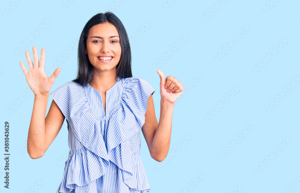 Young beautiful latin girl wearing casual clothes showing and pointing up with fingers number six while smiling confident and happy. Young beautiful latin girl wearing casual clothes showing and pointing up with fingers number six while smiling confident and happy.