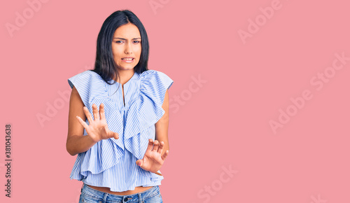 Foto Young beautiful latin girl wearing casual clothes disgusted expression, displeased and fearful doing disgust face because aversion reaction
