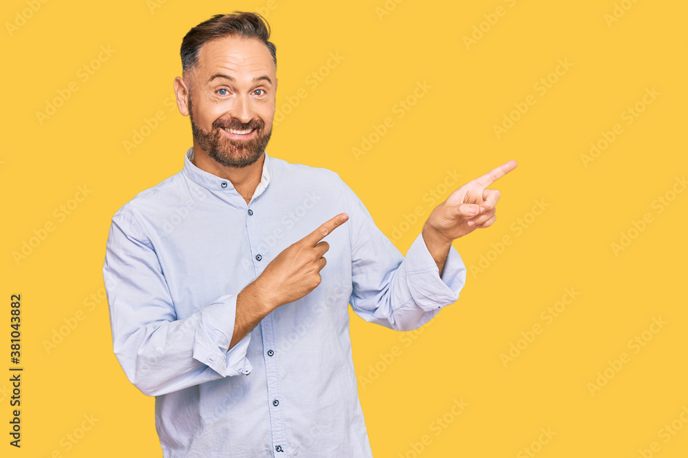 Handsome middle age man wearing business shirt smiling and looking at the camera pointing with two hands and fingers to the side. Handsome middle age man wearing business shirt smiling and looking at the camera pointing with two hands and fingers to the side.