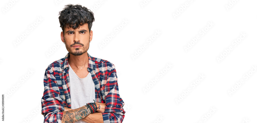 Young hispanic man wearing casual clothes skeptic and nervous, disapproving expression on face with crossed arms. negative person. Young hispanic man wearing casual clothes skeptic and nervous, disapproving expression on face with crossed arms. negative person.