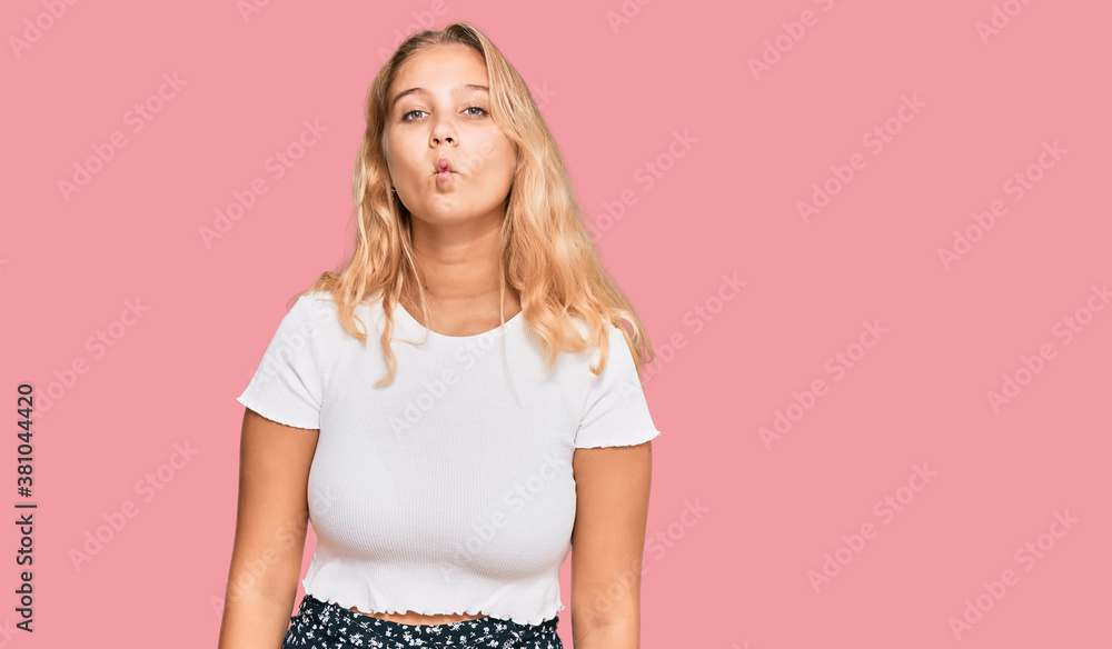 Young blonde girl wearing casual white tshirt making fish face with lips, crazy and comical gesture. funny expression. Young blonde girl wearing casual white tshirt making fish face with lips, crazy and comical gesture. funny expression.