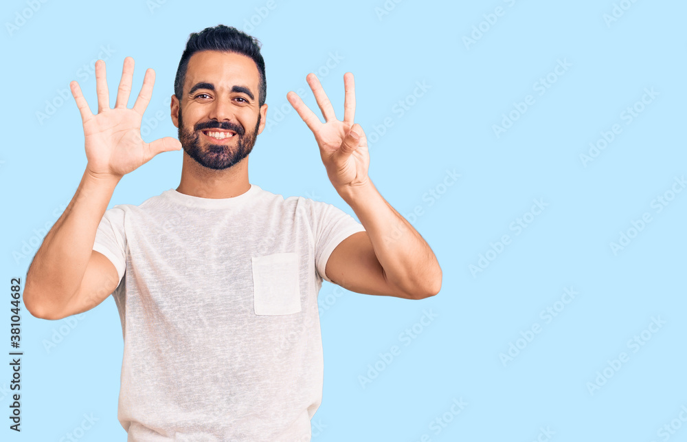 Fototapeta premium Young hispanic man wearing casual clothes showing and pointing up with fingers number eight while smiling confident and happy.