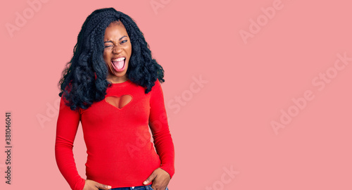 Quadro em tela Beautiful african american woman wearing casual clothes winking looking at the camera with sexy expression, cheerful and happy face