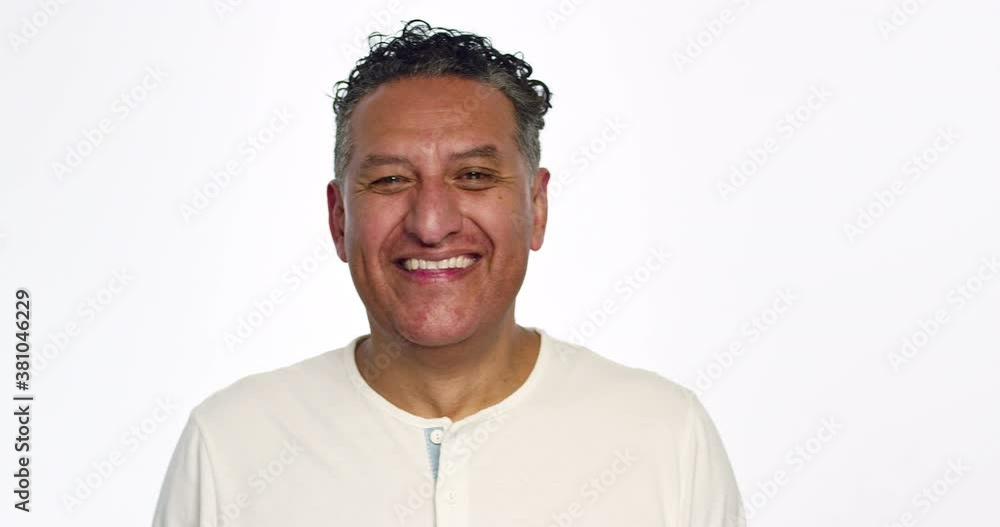 Man in white shirt looks into camera and laughs. Man in white shirt looks into camera and laughs.
