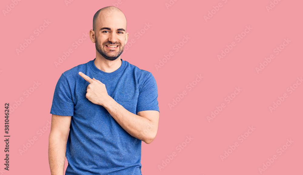 Young handsome man wearing casual t shirt cheerful with a smile of face pointing with hand and finger up to the side with happy and natural expression on face Young handsome man wearing casual t shirt cheerful with a smile of face pointing with hand and finger up to the side with happy and natural expression on face
