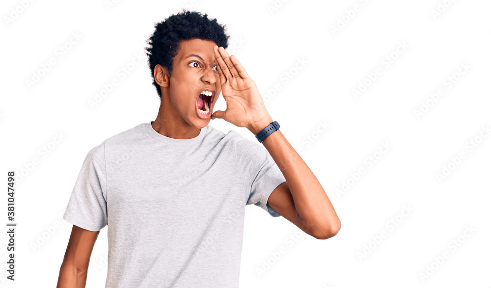 Young african american man wearing casual clothes shouting and screaming loud to side with hand on mouth. communication concept. Young african american man wearing casual clothes shouting and screaming loud to side with hand on mouth. communication concept.