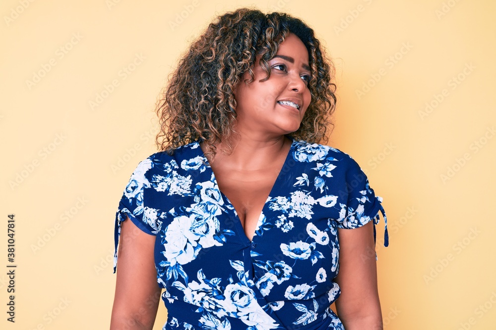 Young african american plus size woman wearing casual clothes looking to side, relax profile pose with natural face and confident smile. Young african american plus size woman wearing casual clothes looking to side, relax profile pose with natural face and confident smile.