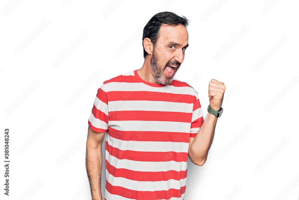 Middle age handsome man wearing striped t-shirt standing over isolated white background pointing thumb up to the side smiling happy with open mouth Middle age handsome man wearing striped t-shirt standing over isolated white background pointing thumb up to the side smiling happy with open mouth