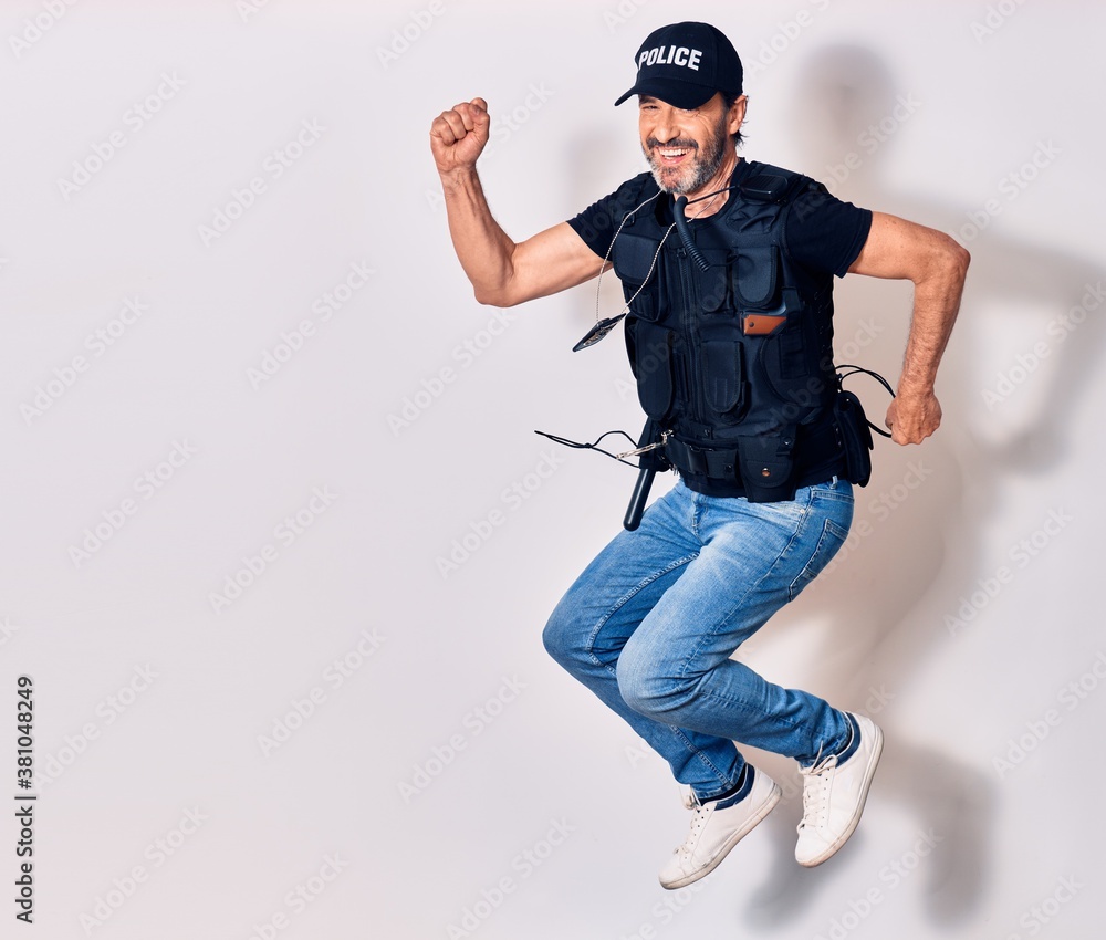 Middle age handsome man wearing police unifrom smiling happy. Jumping with smile on face doing ok sign with fists up over isolated white background Middle age handsome man wearing police unifrom smiling happy. Jumping with smile on face doing ok sign with fists up over isolated white background