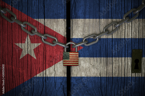 Flag of Cuba painted on old and cracked wooden door, which is closed by an old chain and a padlock. Concept of the economic sanctions of the United States of America to Cuba government 3d render.