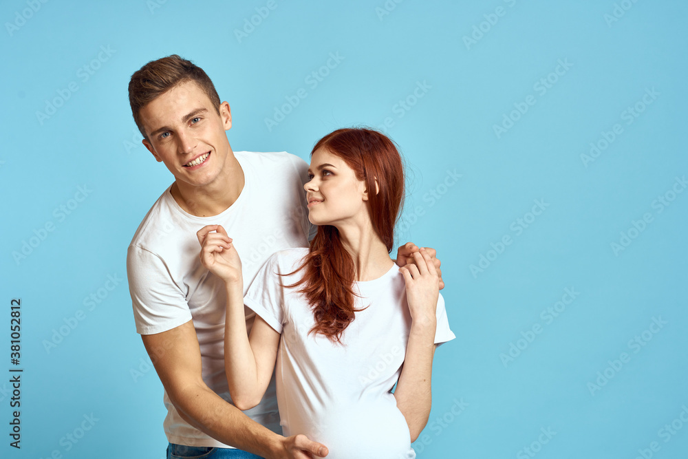 Pregnant woman in white t-shirt and man married couple waiting for baby blue background cropped view of emotions Pregnant woman in white t-shirt and man married couple waiting for baby blue background cropped view of emotions