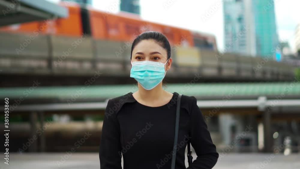 business woman walking and wearing medical mask for protection from coronavirus (covid-19) pandemic in the city business woman walking and wearing medical mask for protection from coronavirus (covid-19) pandemic in the city