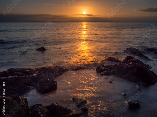Beautiful Seaside Sunrise with Reflections and Rocks