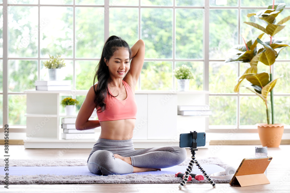 Exercise online training class at home, Asian girl sttretch body while  workout, Healthy asia woman training exercise by mobile phone, Female sport  blogger recording video by smartphone Stock Photo | Adobe Stock