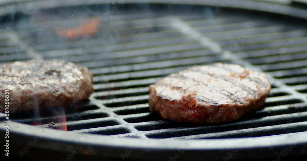 Juicy burger turn on the grill with flames and smoke. Juicy burger turn on the grill with flames and smoke.