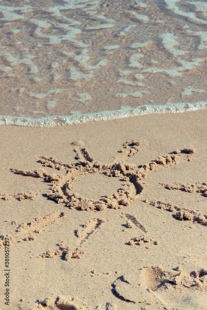 Shape of sun with incoming sea wave on sand at beach. Summer and vacation time Shape of sun with incoming sea wave on sand at beach. Summer and vacation time
